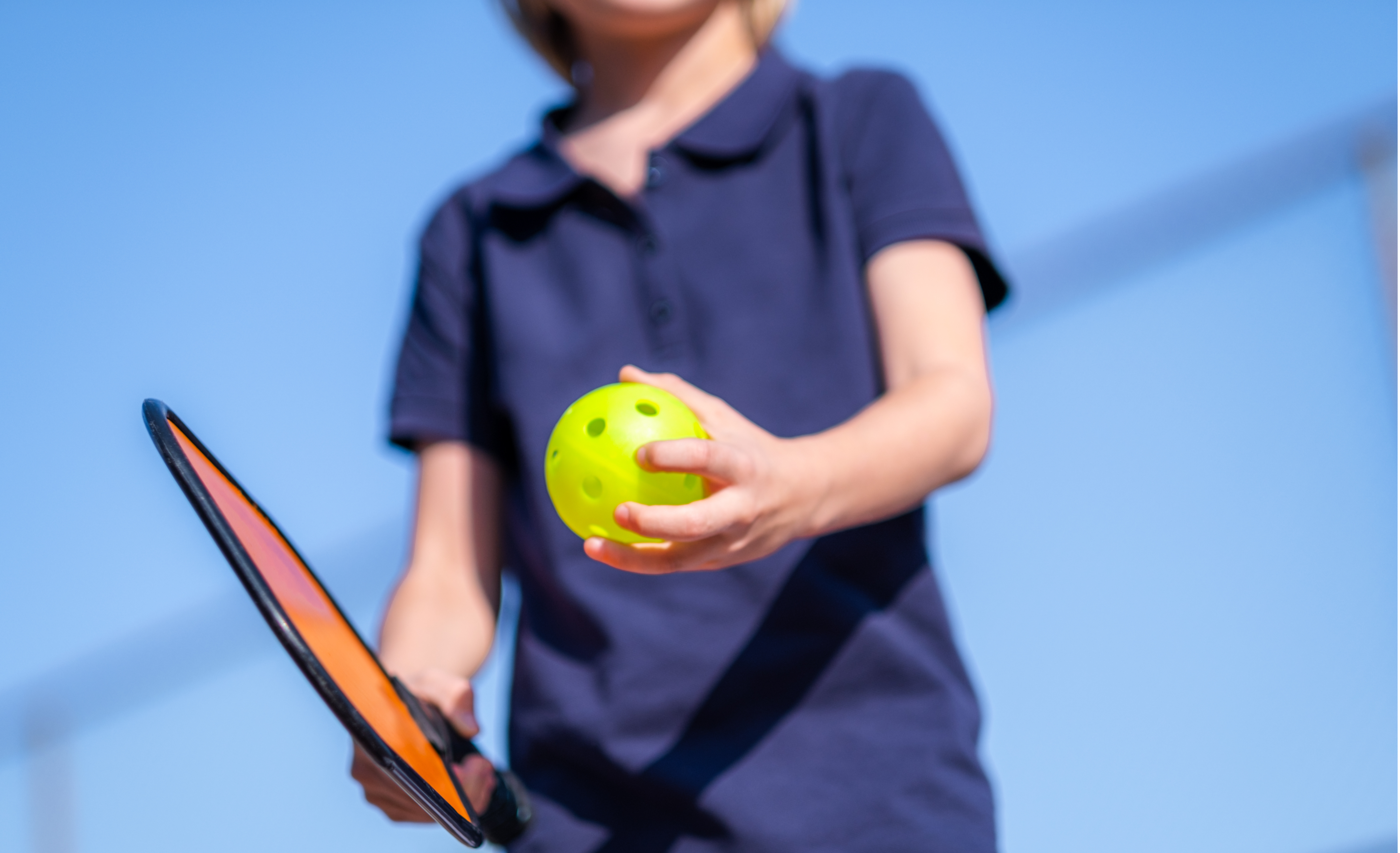 Kid playing pickleball.