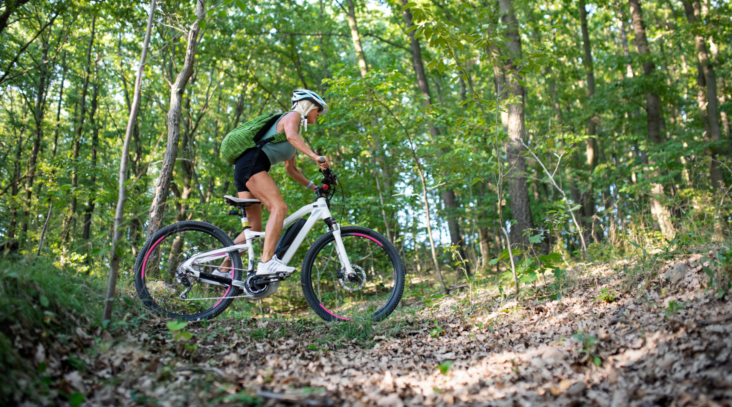 Woman mountain biking in forest