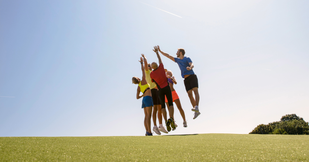 Group of people in athletic wear jumping in celebration, find running clubs in Franklin, TN on FranklinIs.