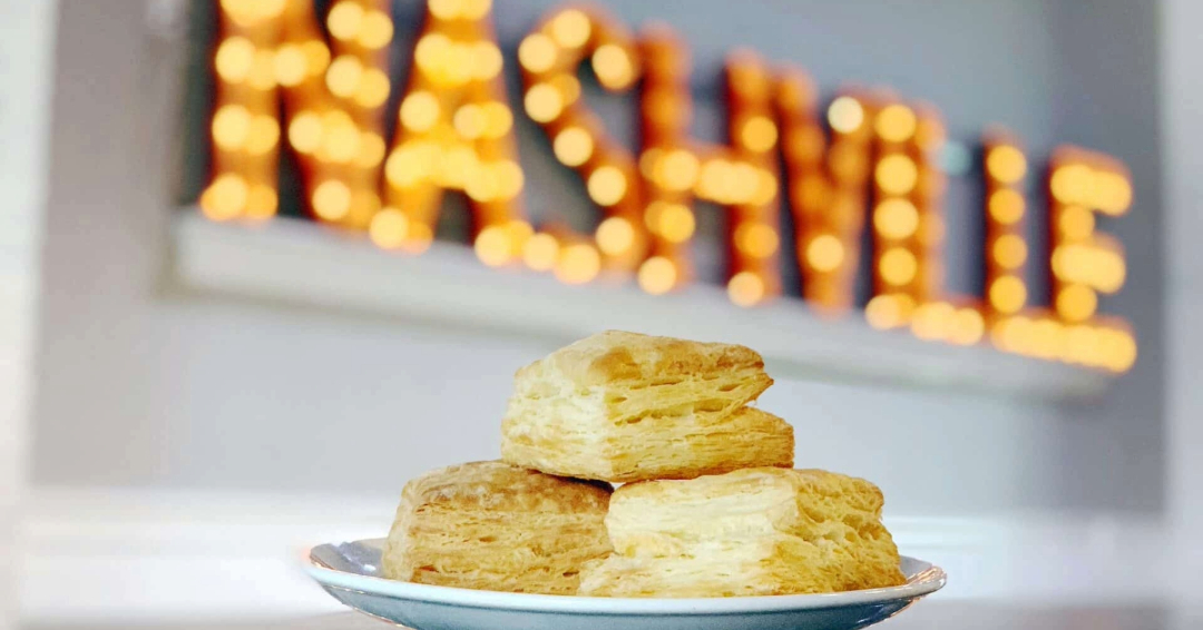 Three Biscuits at Biscuit Love Restaurant in front of a light up sign that reads "Nashville."