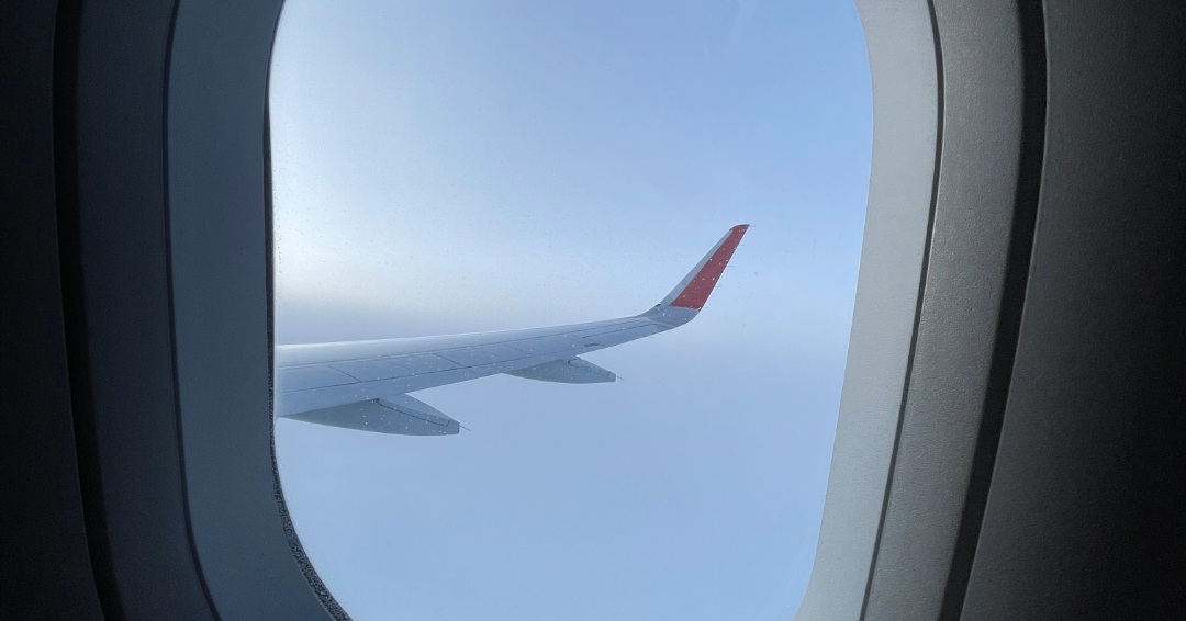 A photo of an airplane wing in flight out the window.