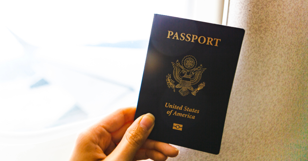 A woman's hand holds an official U.S. passport. 