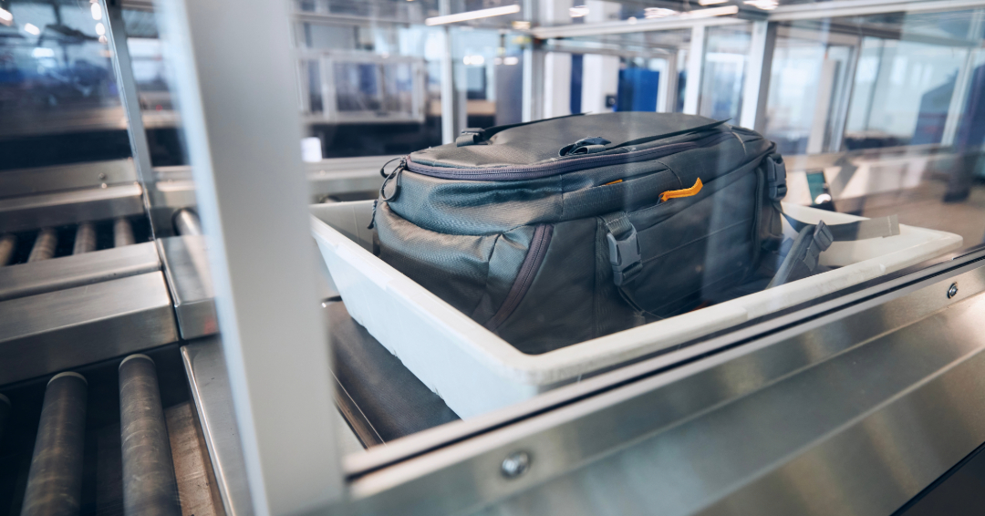 Gray suitcase going through TSA check at the airport.