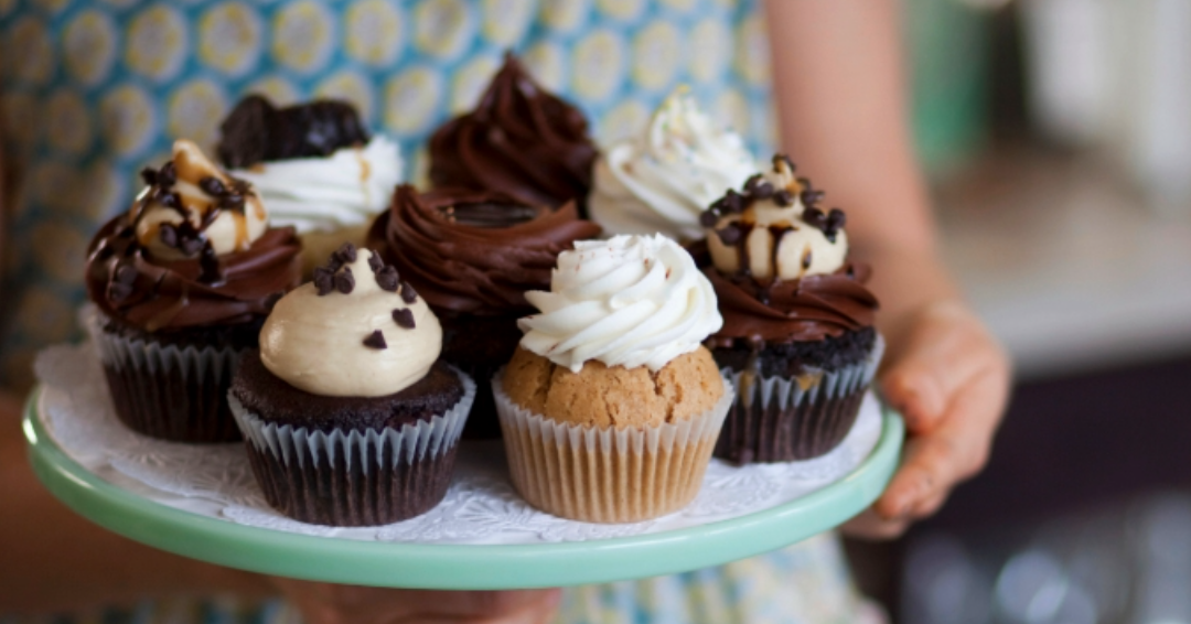 Vegan and gluten free bakery in Franklin,. TN, a woman holds deserts and cupcakes that are food-allergy friendly.