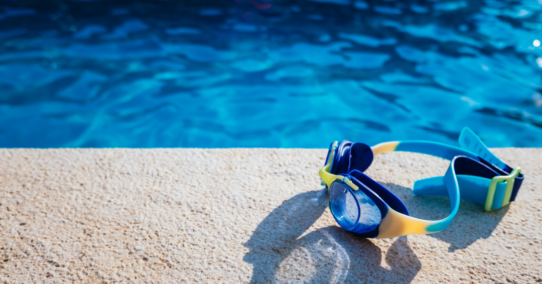 A public swimming pool in Franklin, Tennessee, goggles laying by the blue pool.