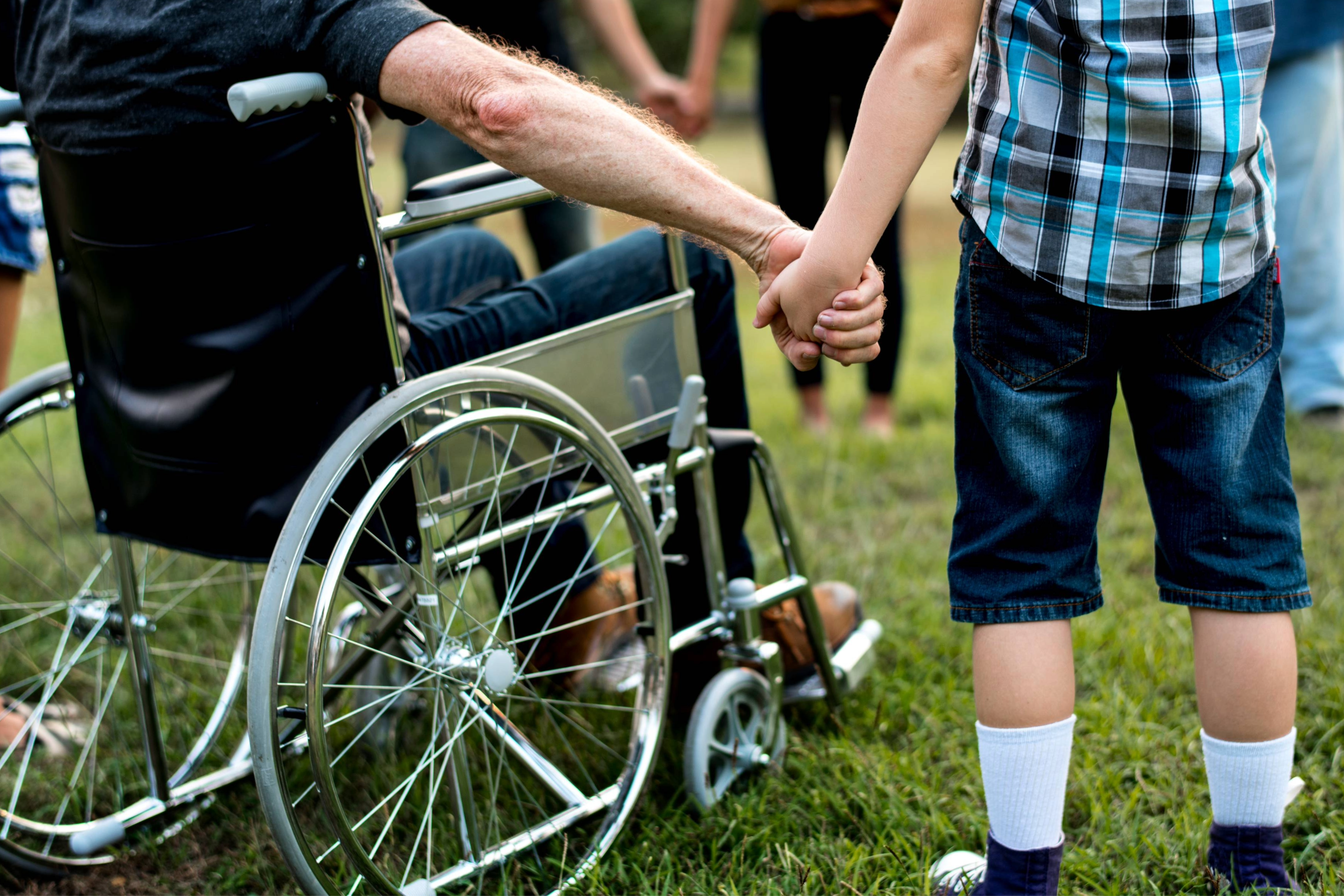 A group of people holding hands, featuring a man in a wheelchair. Williamson County, Tennessee, has resources for people with developmental and intellectual disabilities.