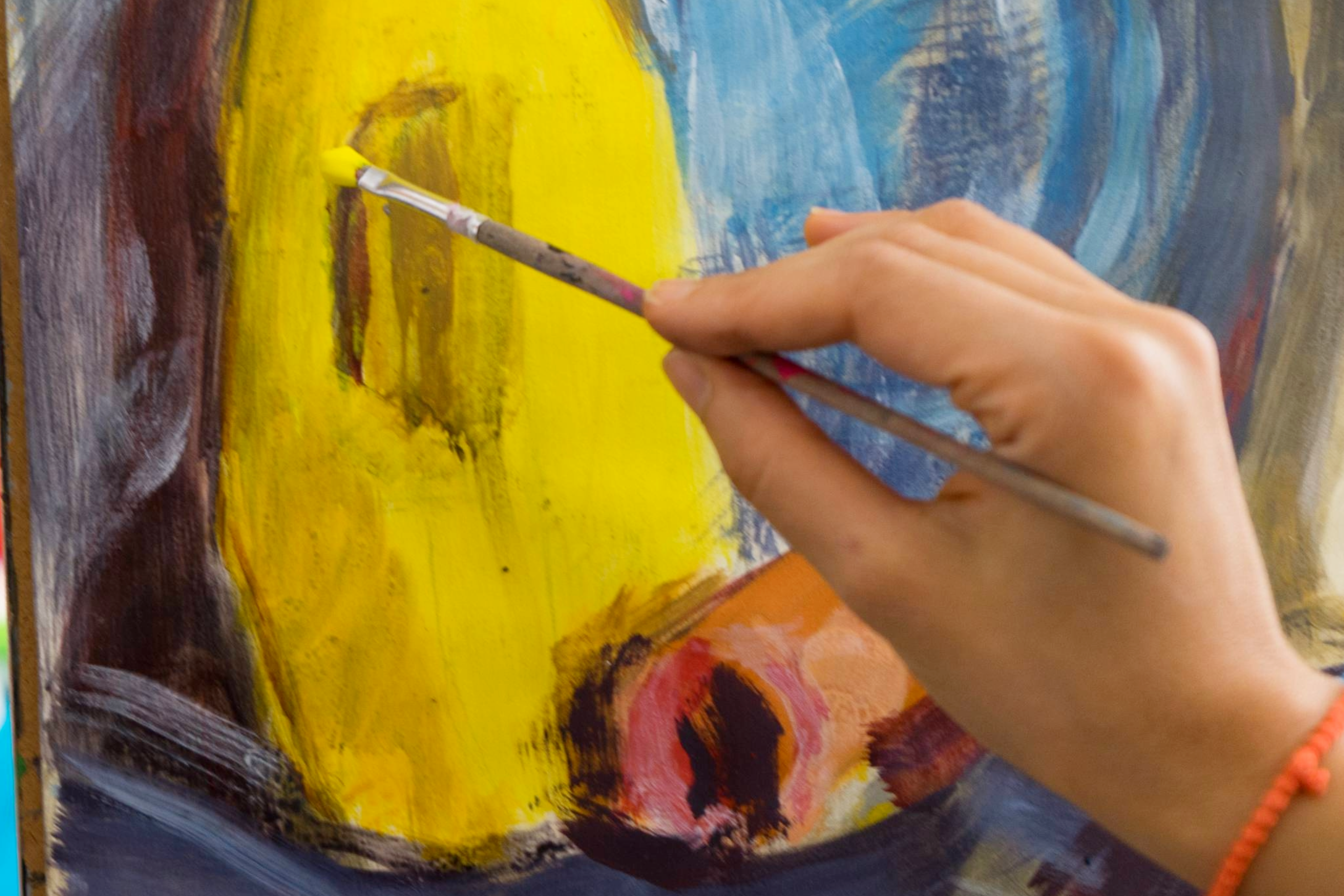 At a Franklin Art Crawl, a woman paints yellow onto a canvas, showcasing the vibrant art scene in Williamson County, Tennessee. 