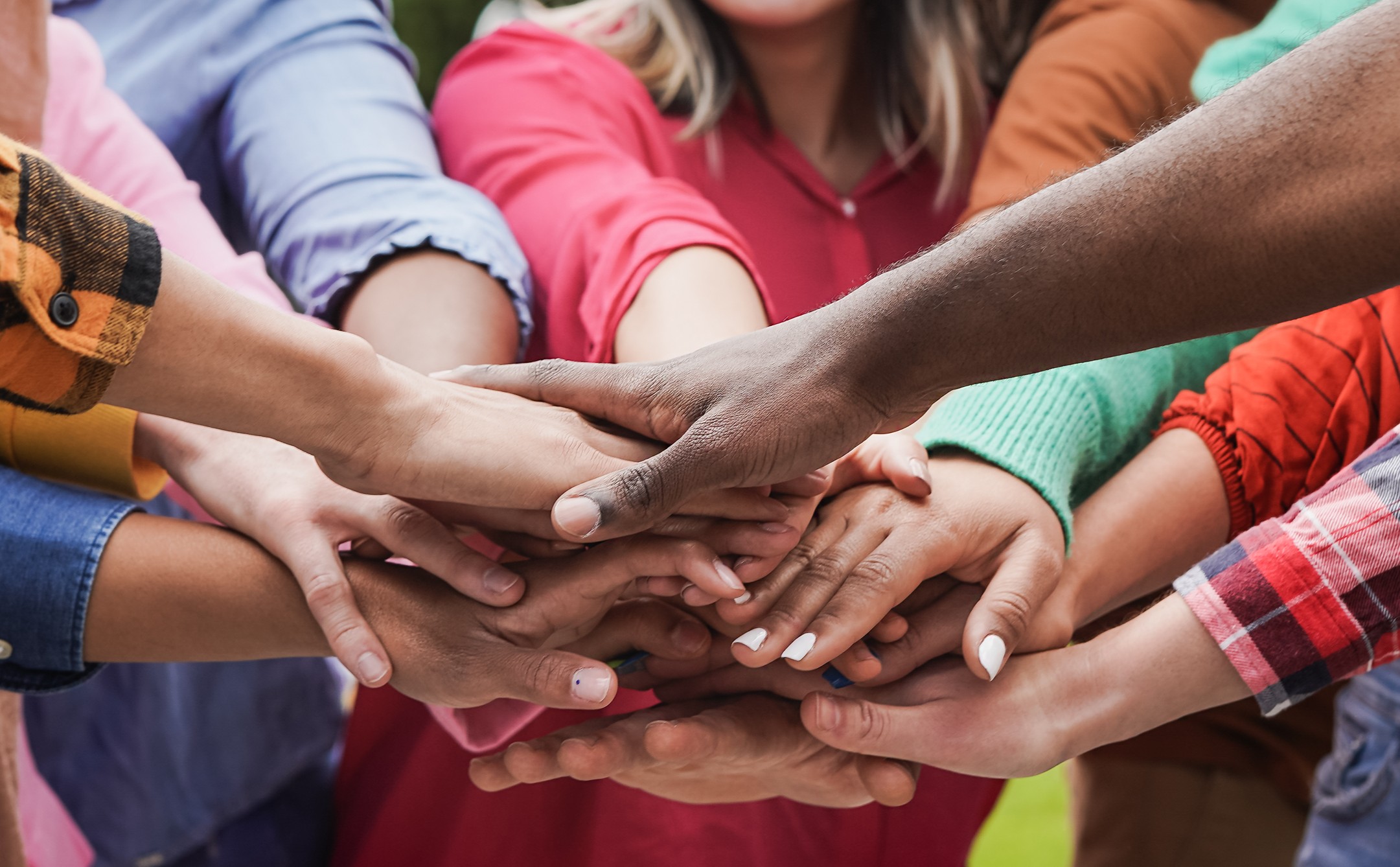 A group of people stacking hands, representing accessibility and unity across abilities in Franklin and Williamson County, Tennessee.