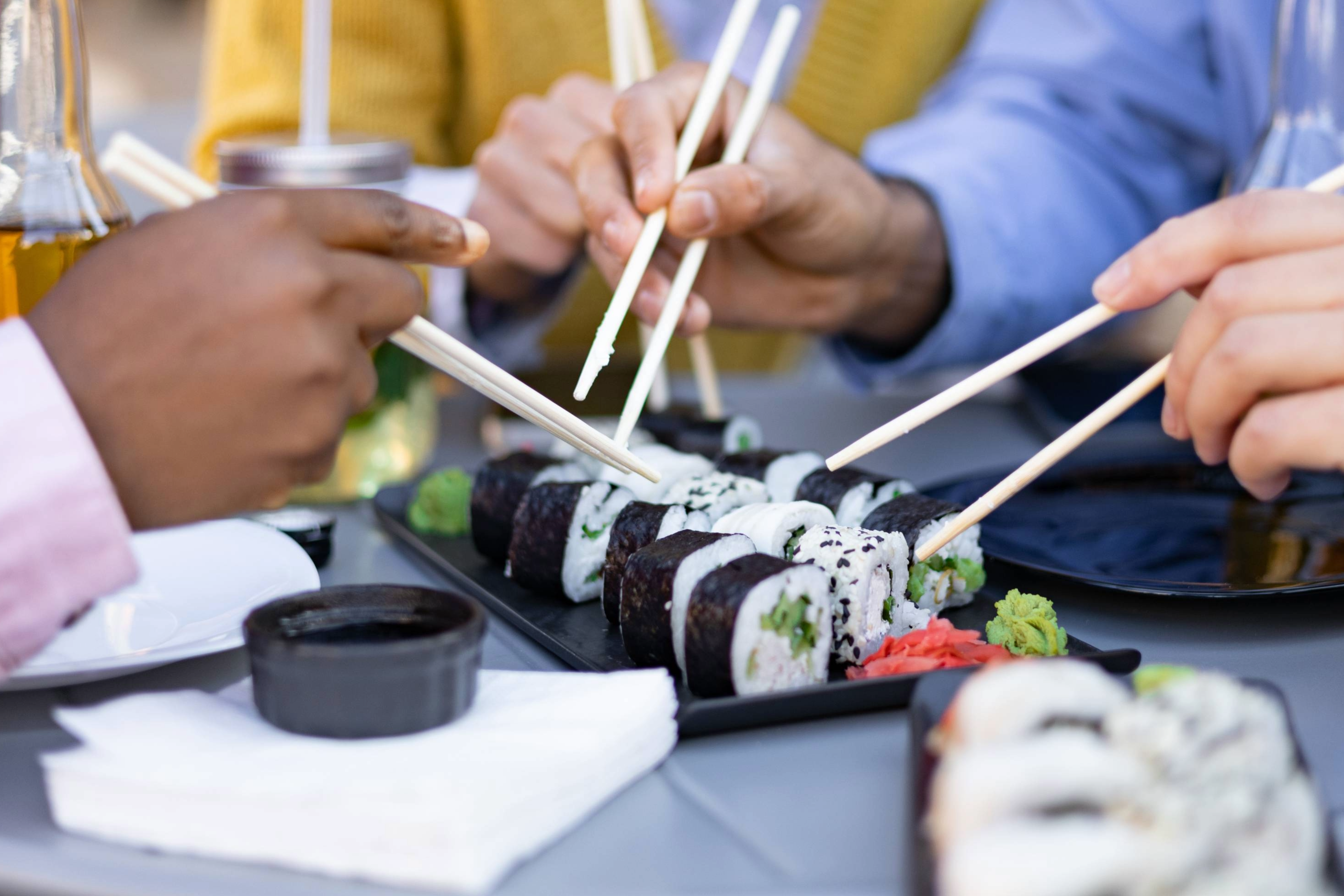 Friends enjoy sushi, dining at a restaurant in Franklin, Tennessee, sushi rolls, Sake and Thai and Japanese cuisine.
