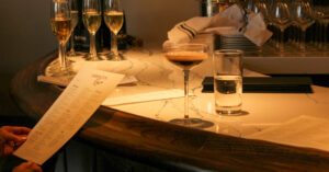 A woman holding a menu at the bar at Karrington Rowe in Brentwood, TN., with an Espresso Martini.
