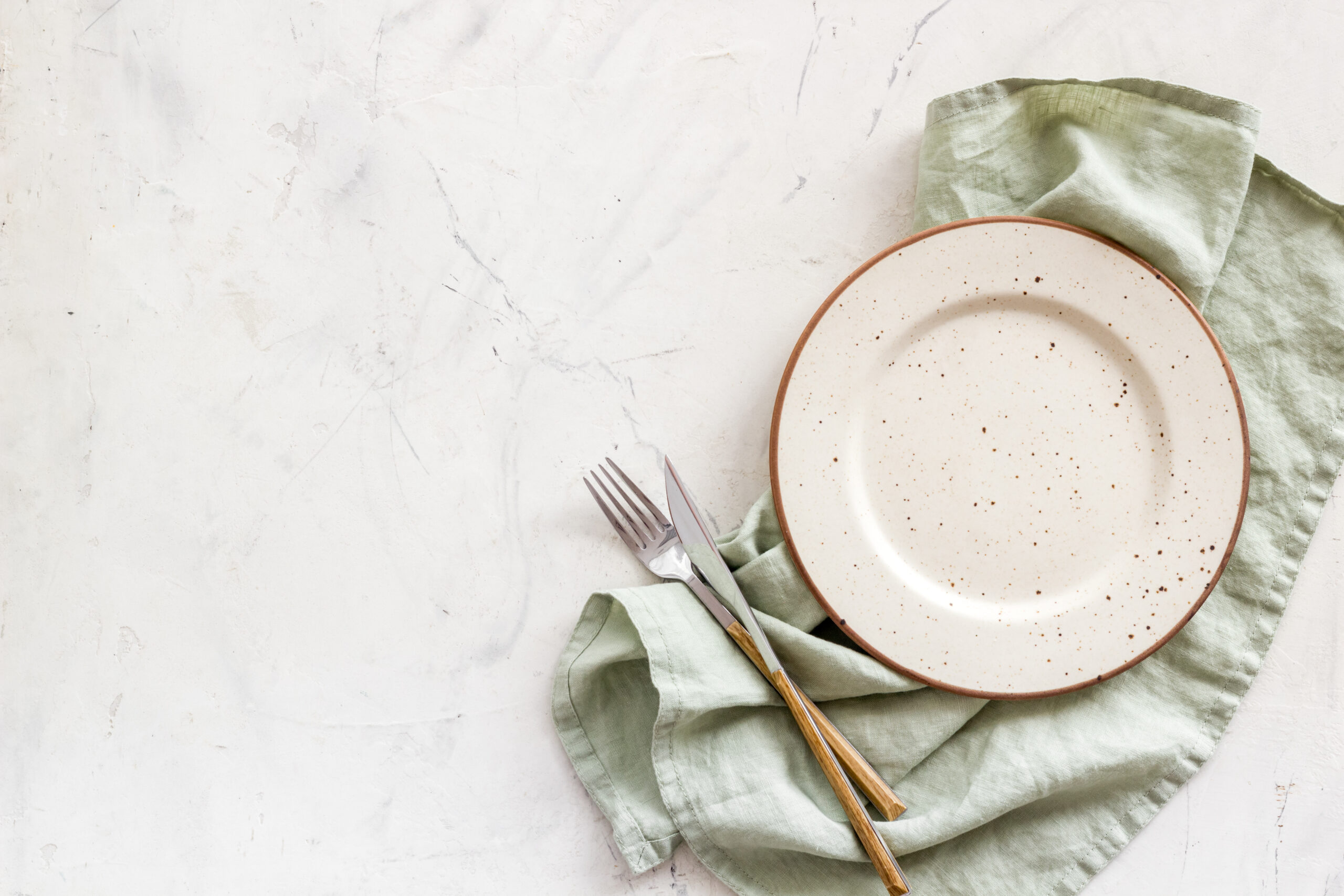Empty dish and cutlery on napkin. Table setting top view
